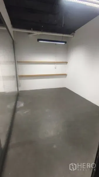 办公空间 出租在Pathum Wan, Bangkok - 小型会议室，水泥地、白墙、悬浮置物板和LED灯。