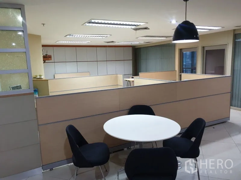 Office Space for rent - Pantry or breakout corner with a round table, four chairs and a pendant lamp.