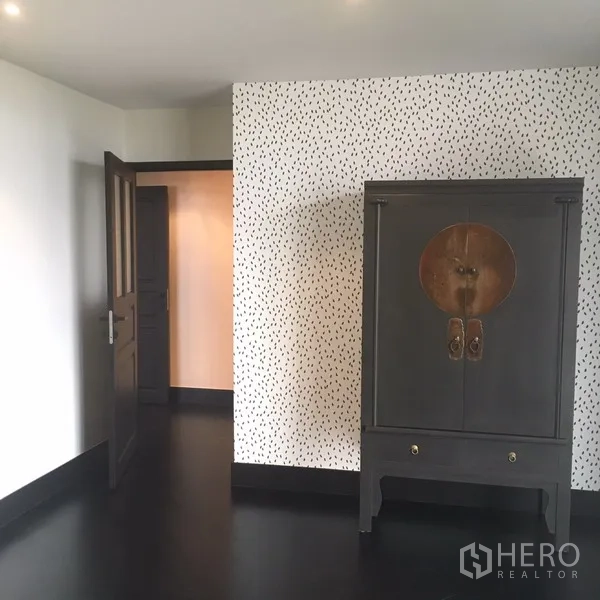 คอนโด ให้เช่าในWatthana, Bangkok - มุมห้องนอน ตู้ไม้สีเข้มตั้งเด่นคู่ผนังลาย และพื้นสีดำ.