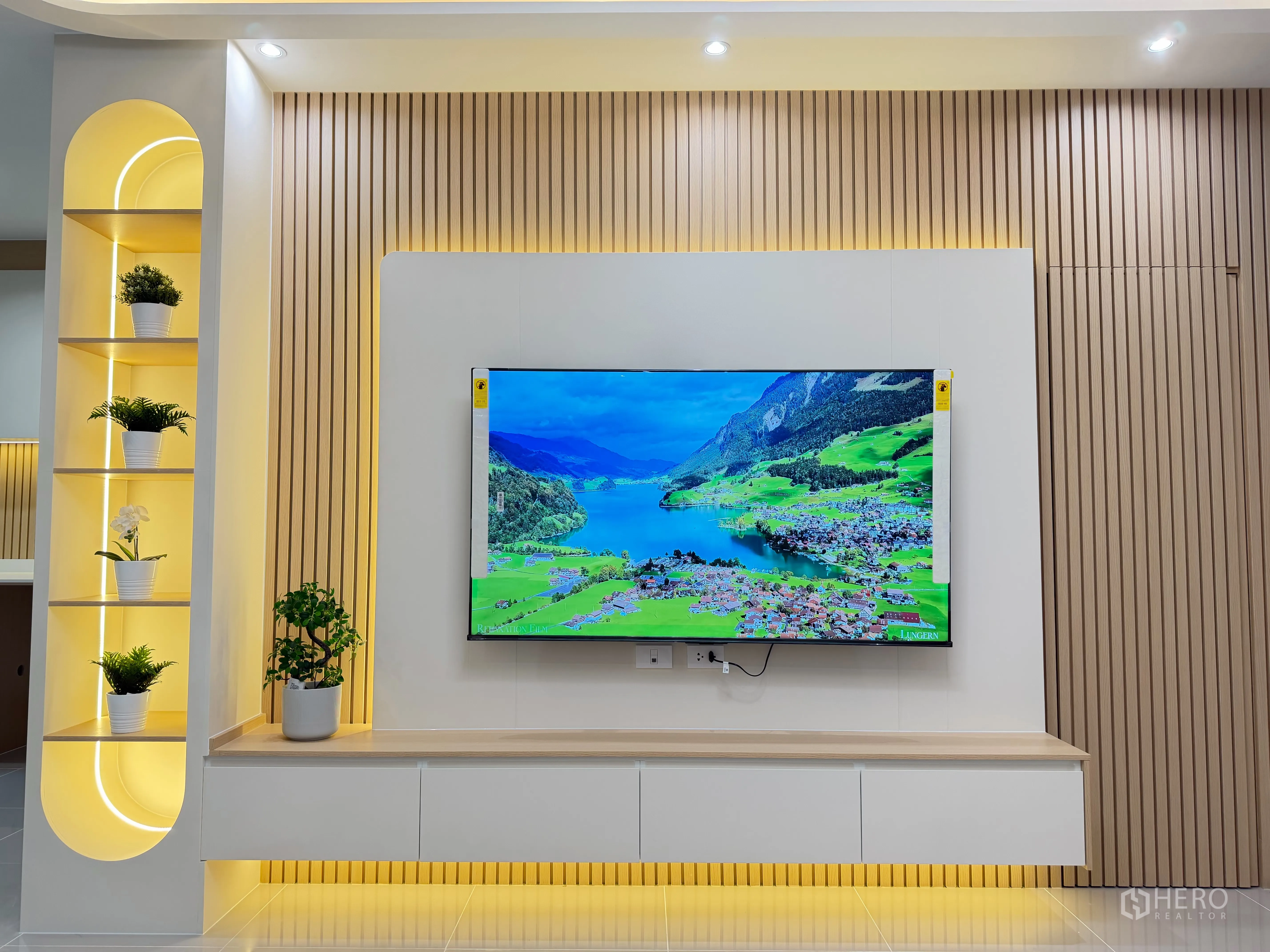 Townhouse for rent in Bang Phli, Samut Prakan - Living room TV feature wall with LED lighting and display shelves.