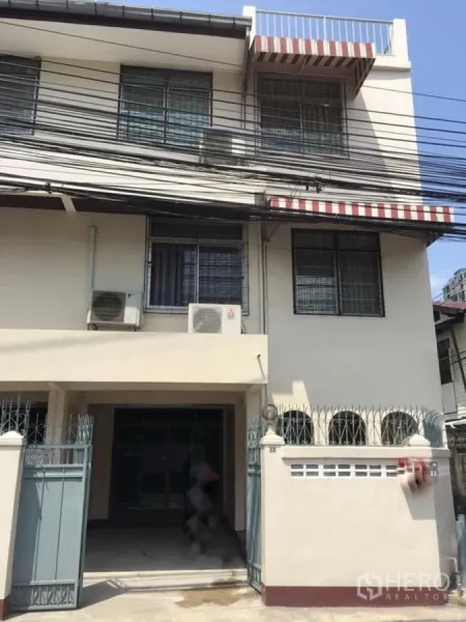 Townhouse for rent in Khlong Toei, Bangkok - Three-storey townhouse facade with gated entry near BTS Ekkamai.