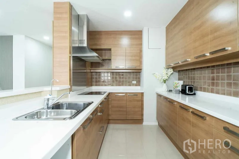 คอนโด ขายในWatthana, Bangkok - ครัวรูปตัวยูบิลต์อินไม้ เคาน์เตอร์สีขาว อ่างล้างจานสเตนเลสและเครื่องดูดควัน