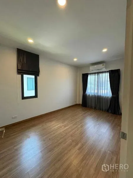 Detached House for rent in Don Mueang, Bangkok - Air-conditioned bedroom with wooden floor, recessed lights and windows.