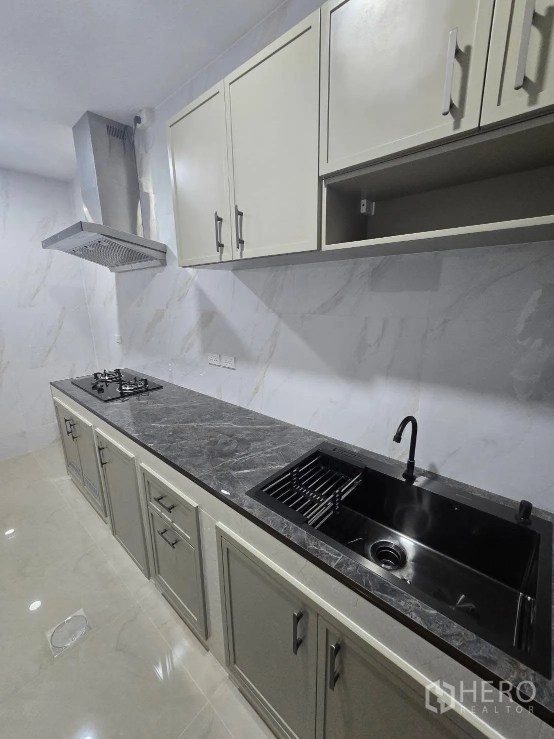 Semi-detached House for rent in Bang Phli, Samut Prakan - Modern linear kitchen with stone countertop, gas hob, hood, and black sink.