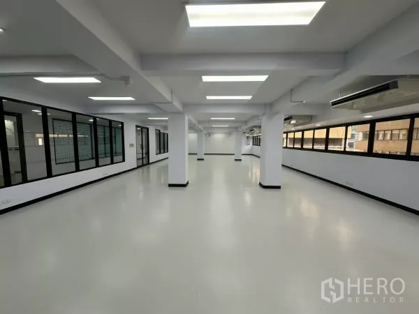 办公空间 出租 - 狭长型办公区域，长窗、空调设备与玻璃会议室。