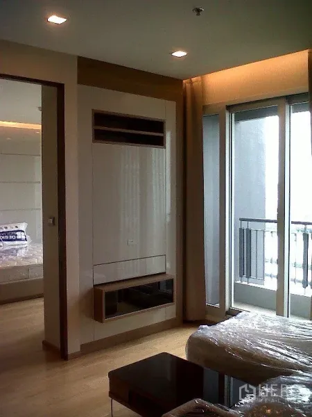 Condominium for rent or sale in Ratchathewi, Bangkok - Bright living area with floor-to-ceiling windows and a balcony at a modern Bangkok condo.