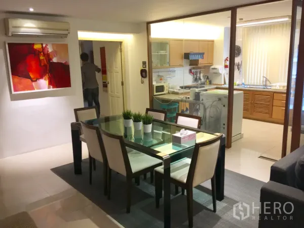公寓 出租在Bang Rak, Bangkok - 采光良好的餐区，玻璃餐桌，旁为封闭式厨房与家电。