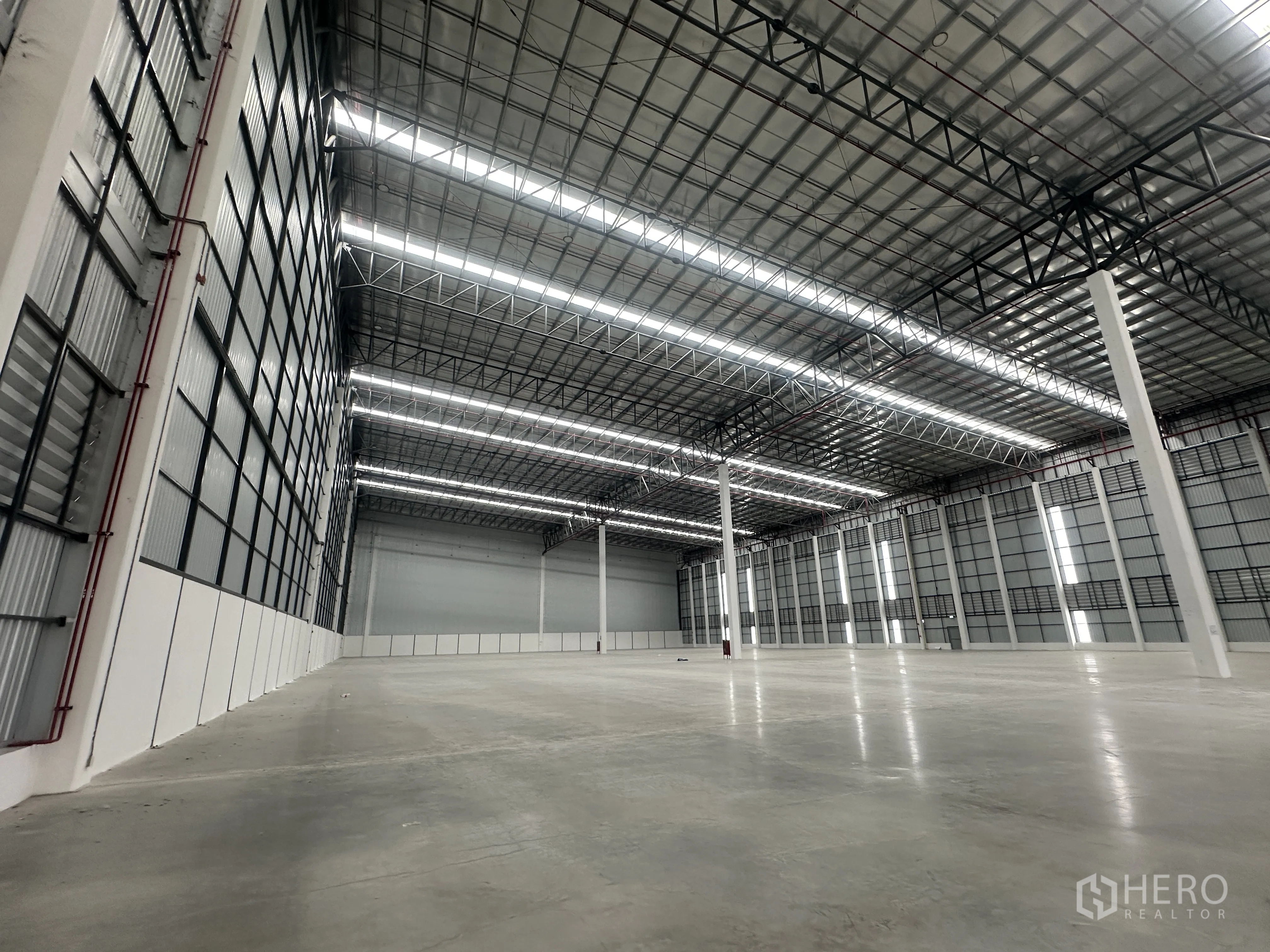 Factory for rent in Bang Phli, Samut Prakan - Wide clear-span warehouse area with metal roof and tall side walls.