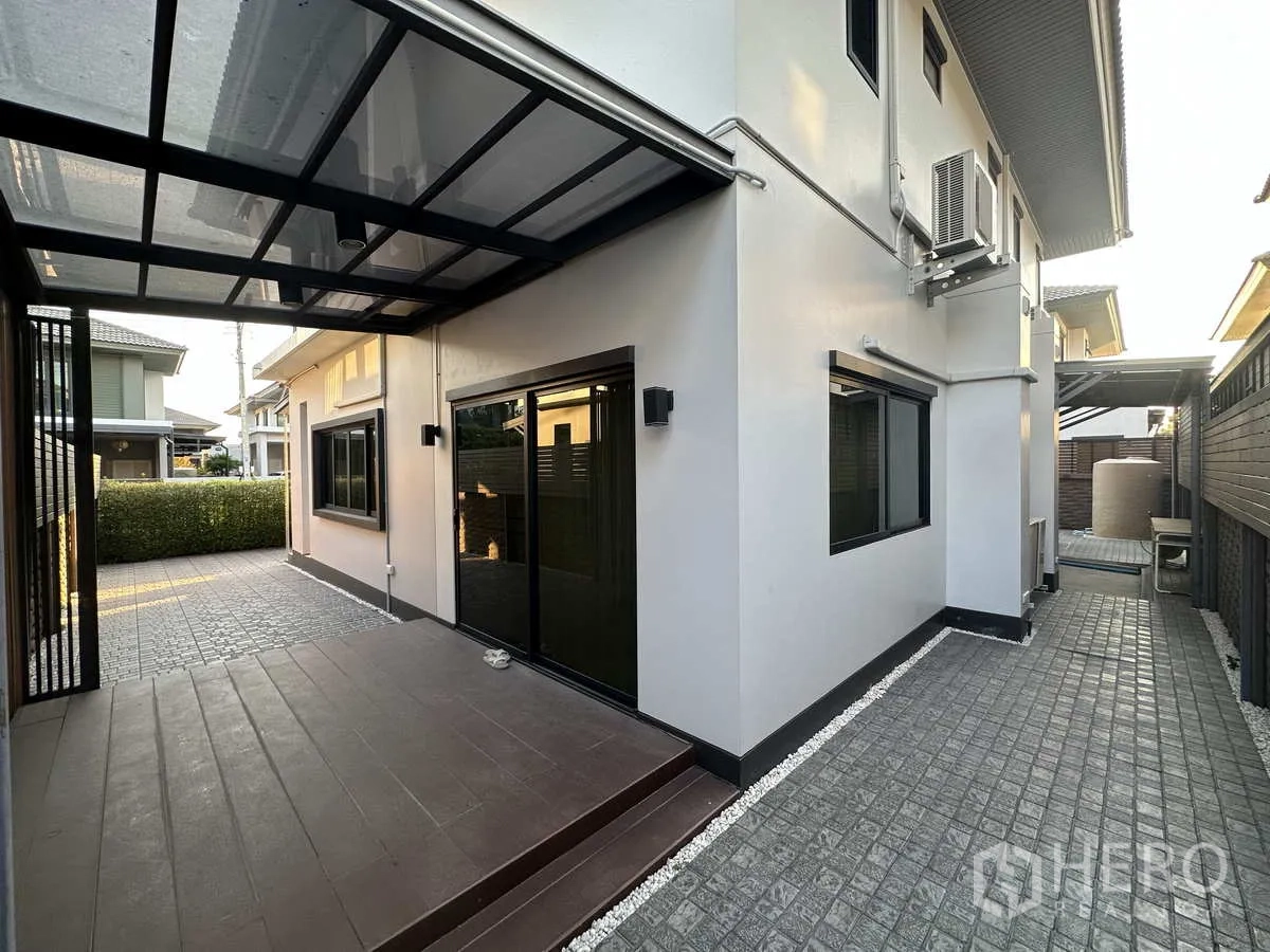 บ้าน ให้เช่าหรือขายในLam Luk Ka, Pathum Thani - ลานข้างบ้านมีหลังคา เชื่อมประตูบานเลื่อน และลานปูพื้นดูแลง่าย.