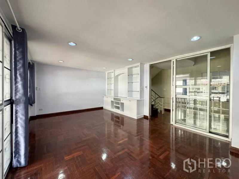 ทาวน์เฮาส์ ให้เช่าหรือขายในSuan Luang, Bangkok - ห้องนั่งเล่นอีกมุมกับผนังกระจกกั้นและชั้นวางบิวท์อิน