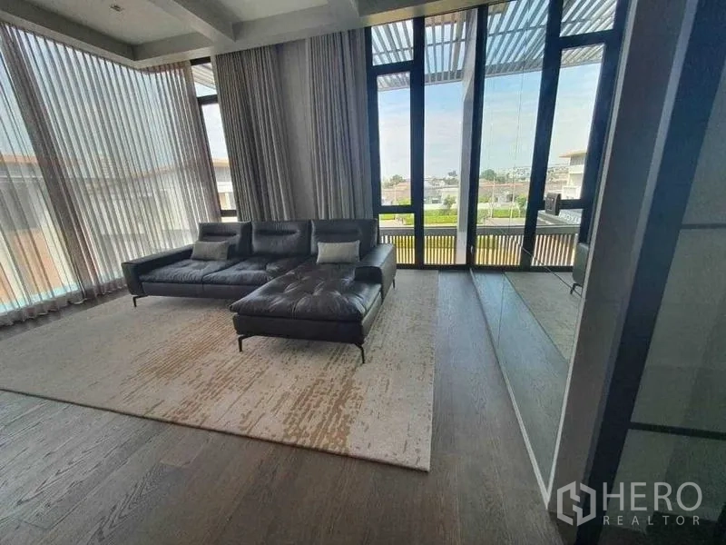 Detached House for rent or sale in Prawet, Bangkok - Sitting area with panoramic glazing and mirrored feature wall.