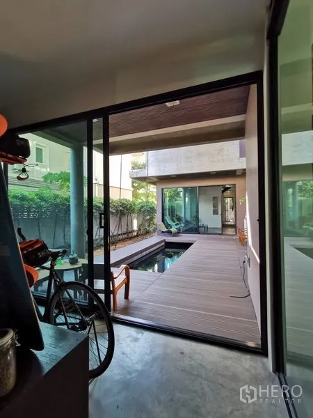 Home Office for sale in Wang Thonglang, Bangkok - Sliding glass doors opening to a decked courtyard with reflecting pond and seating.
