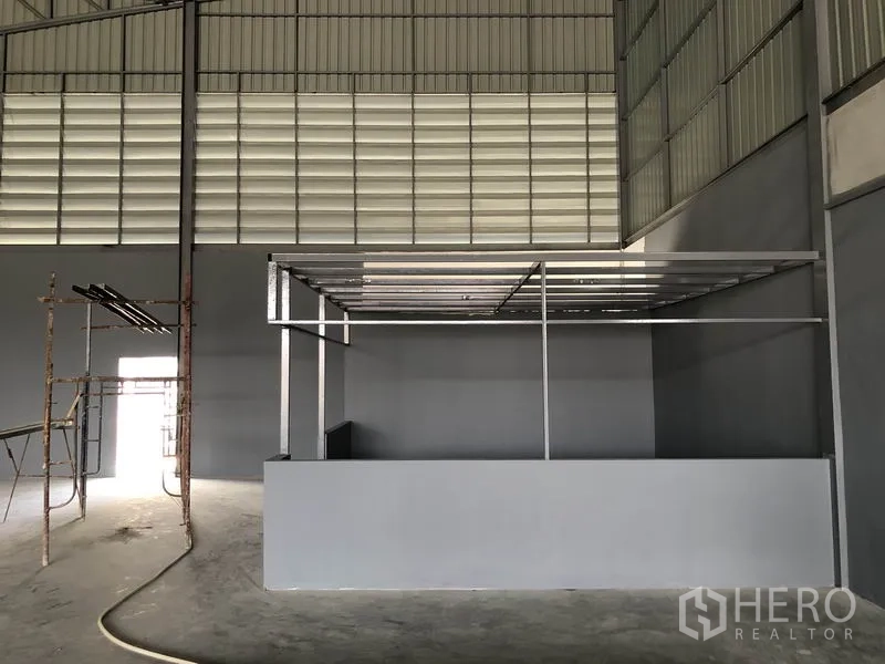 Warehouse for rent in Bang Khen, Nonthaburi - Close-up of built-in office frame beneath louvered wall panels inside the warehouse.