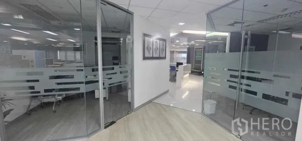 办公空间 出租在Bang Rak, Bangkok - 前厅走道通向玻璃隔断办公室，自然采光与木地板相映成趣。