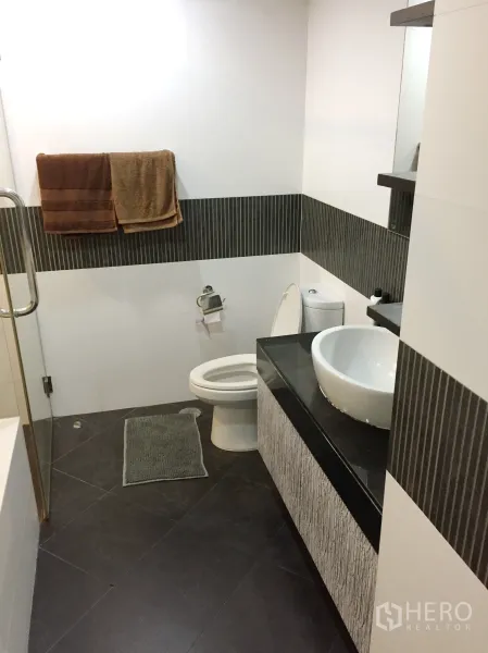 公寓 出租或出售在Sathon, Bangkok - 现代卫浴，台上盆、深色地砖与马桶布局整洁。