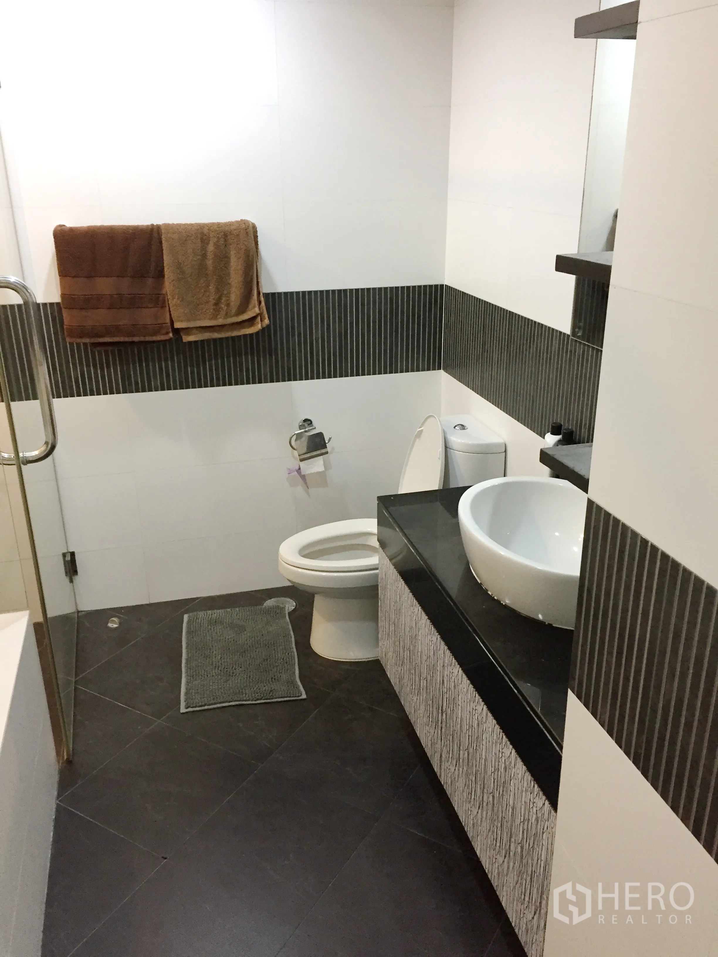 公寓 出租或出售在Sathon, Bangkok - 现代卫浴，台上盆、深色地砖与马桶布局整洁。