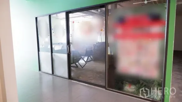 零售空间 出租在Watthana, Bangkok - 室内走廊旁的玻璃店面，推拉门与磨砂玻璃提升私密与展示效果。