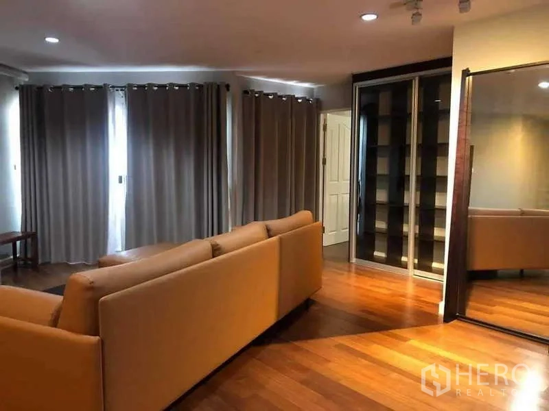 公寓 出售在Yan Nawa, Bangkok - 起居区配整面窗帘与玻璃陈列柜。