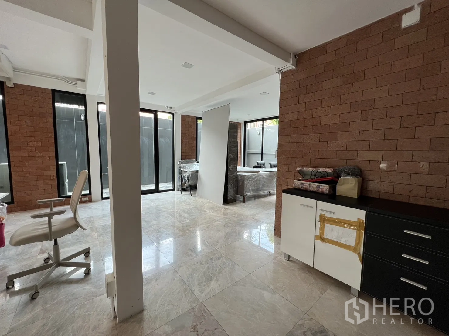 บ้าน ให้เช่าหรือขายในPhra Khanong, Bangkok - พื้นที่ชั้นล่างโล่ง โปร่ง มีผนังอิฐและมุมทำงาน