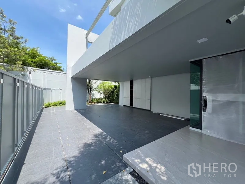 Detached House for rent in Saphan Sung, Bangkok - Covered carport and tiled patio beside a landscaped garden.