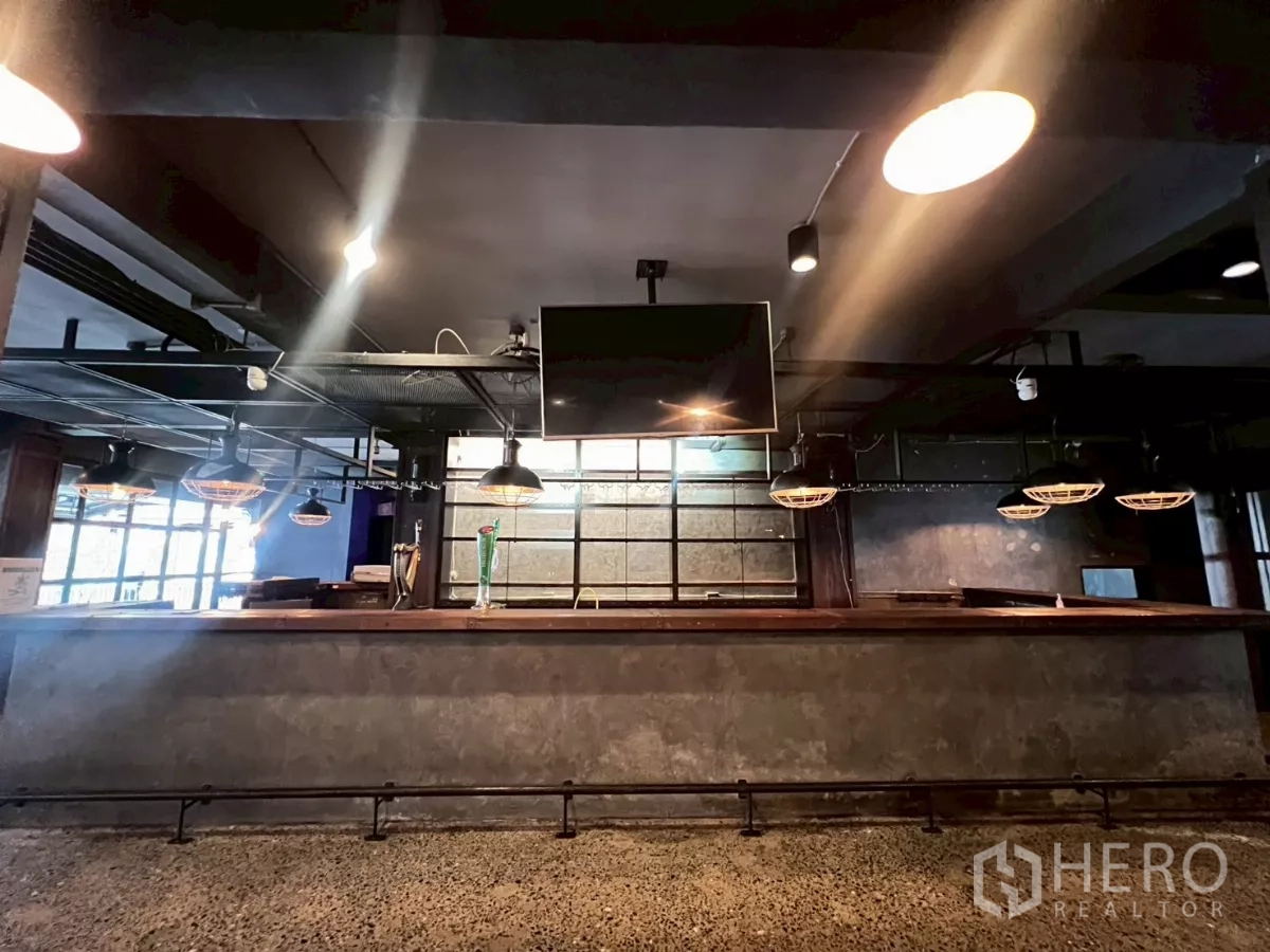 零售空间 出租 - 正面长吧台，吊灯与壁挂电视一字排开。