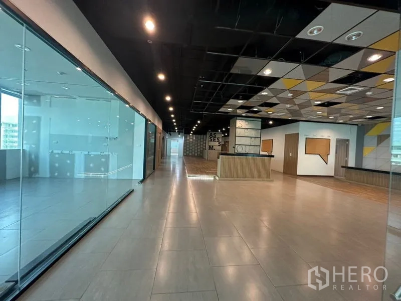 Office Space for rent in Ratchathewi, Bangkok - Hallway with glass partitions, geometric ceiling and reception area.