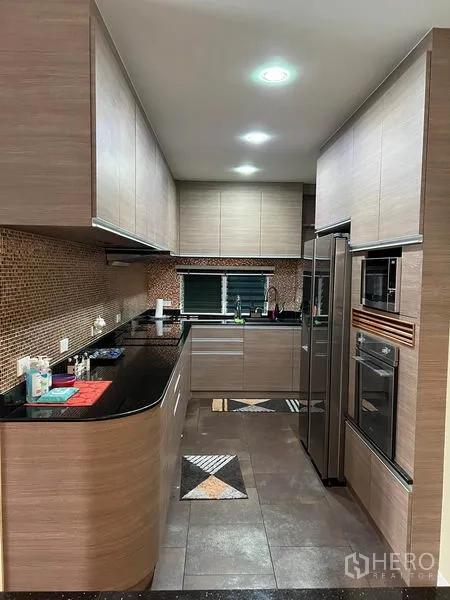 Detached House for rent in Bang Kapi, Bangkok - U-shaped kitchen with wood cabinetry, black granite counters and built-in appliances.