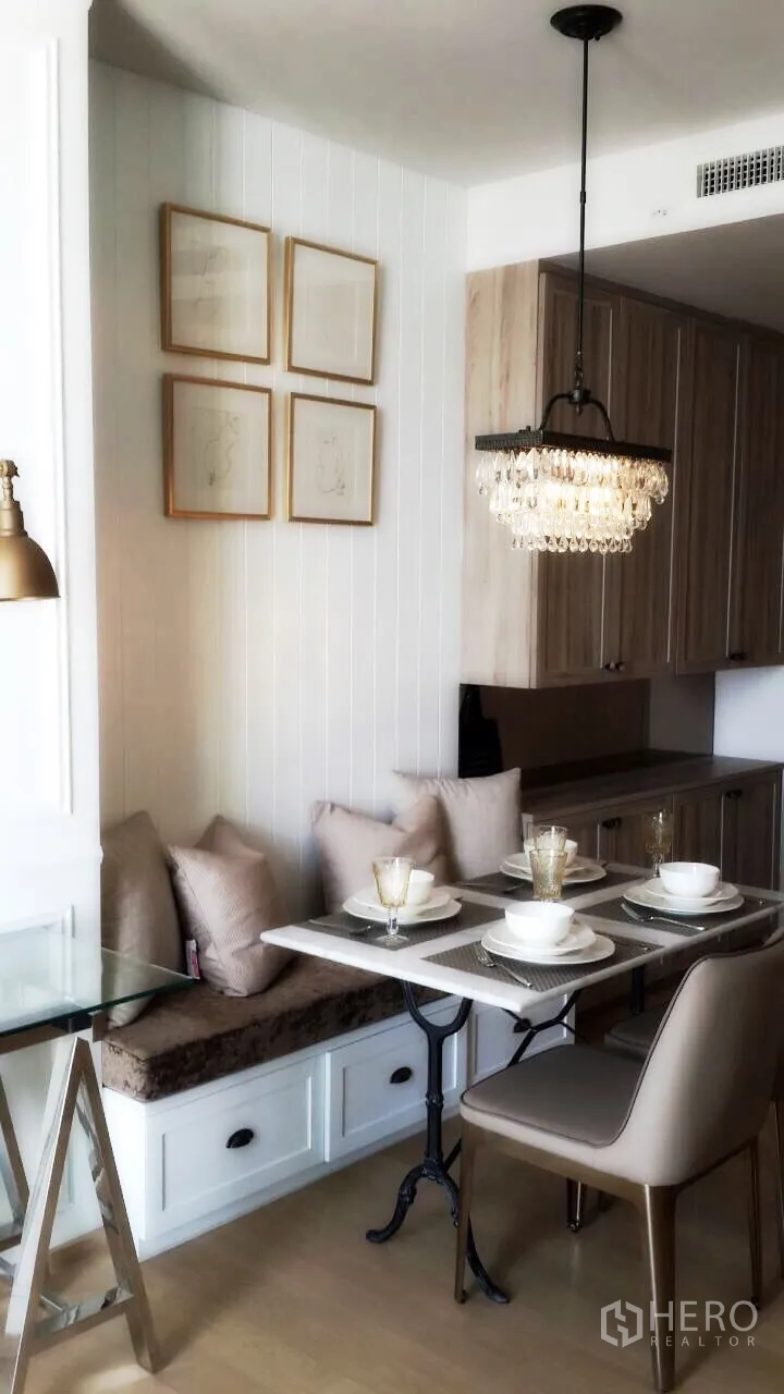 คอนโด ให้เช่าในPhaya Thai, Bangkok - มุมทานอาหารสว่างพร้อมเบาะนั่งมีลิ้นชัก ภาพติดผนัง และโคมไฟแขวนข้างครัว