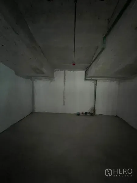 零售空间 出租在Pathum Wan, Bangkok - 混凝土墙顶的空置后场房间，带基础管线。