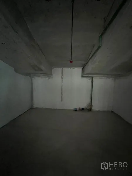 零售空间 出租在Pathum Wan, Bangkok - 混凝土墙顶的空置后场房间，带基础管线。