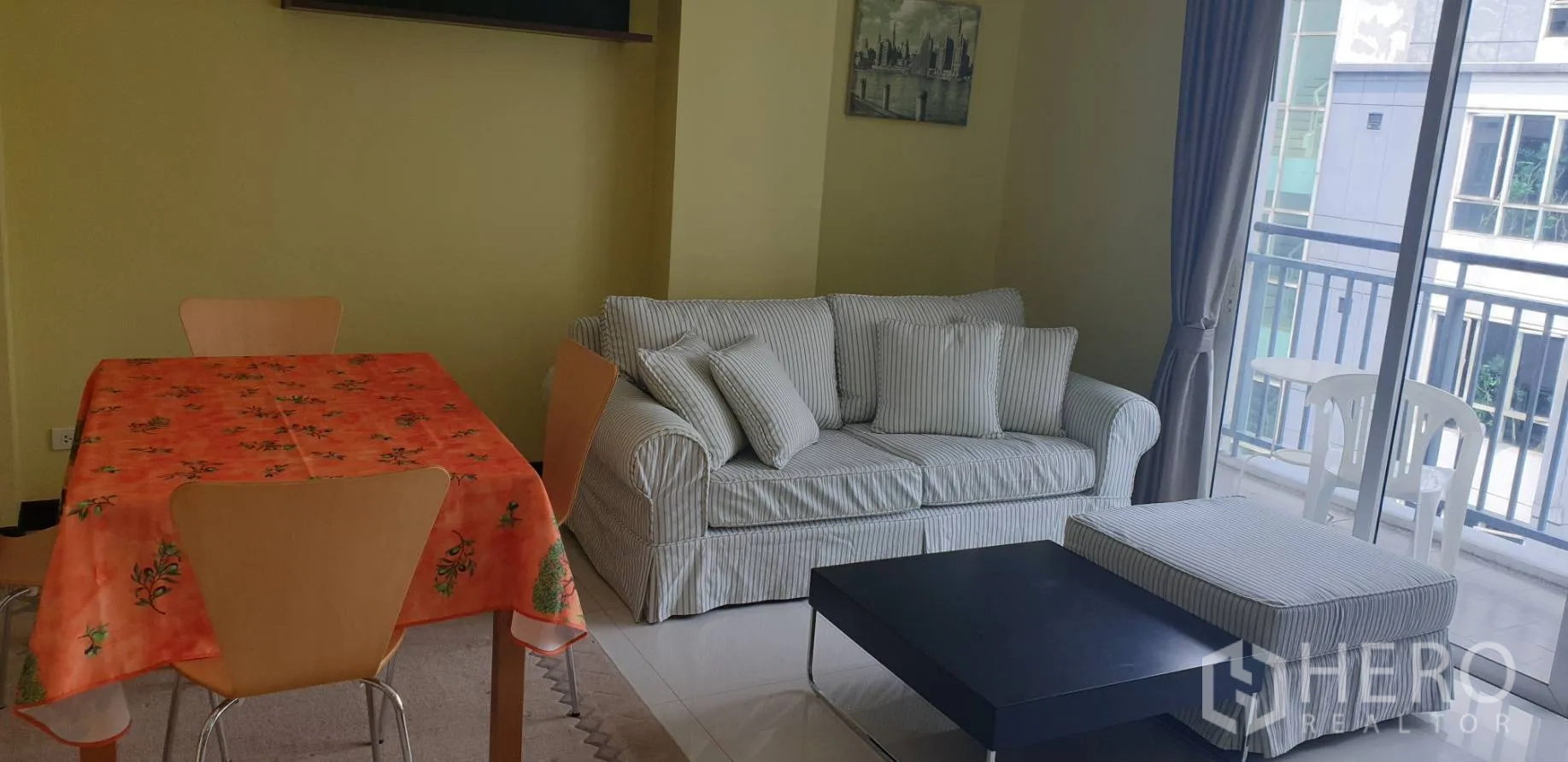 คอนโด ให้เช่าในKhlong Toei, Bangkok - ห้องนั่งเล่นโซฟาลายทาง ชุดโต๊ะทานข้าว โต๊ะกลาง และประตูสไลด์ออกระเบียง