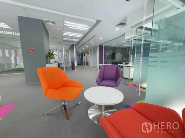 สำนักงาน ให้เช่าในRatchathewi, Bangkok - โซนพักผ่อนพร้อมเก้าอี้สีสดและโต๊ะกลมข้างผนังกระจก