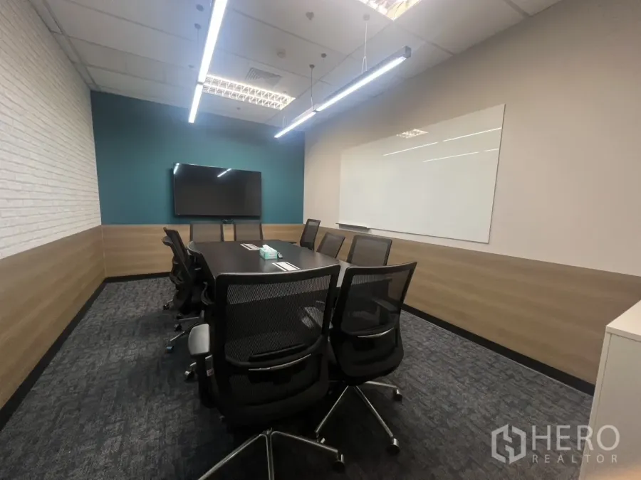 Office Space for rent in Huai Khwang, Bangkok - Conference room featuring a long table, mesh chairs, wall‑mounted TV and large whiteboard with linear ceiling lights.