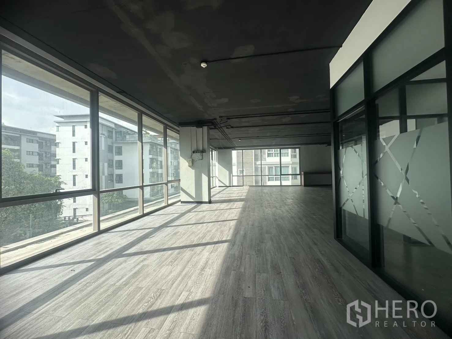 สำนักงาน ให้เช่าในKhlong Toei, Bangkok - ออฟฟิศแบบโอเพ่นสเปซรับแสงธรรมชาติด้วยกระจกเต็มบานและพื้นไวนิลสีเทา เขตคลองเตย