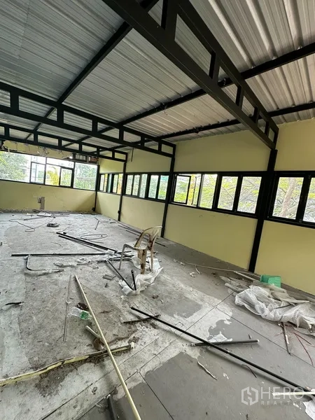 Detached House for rent in Watthana, Bangkok - Overgrown lawn area with trees and a boundary wall.