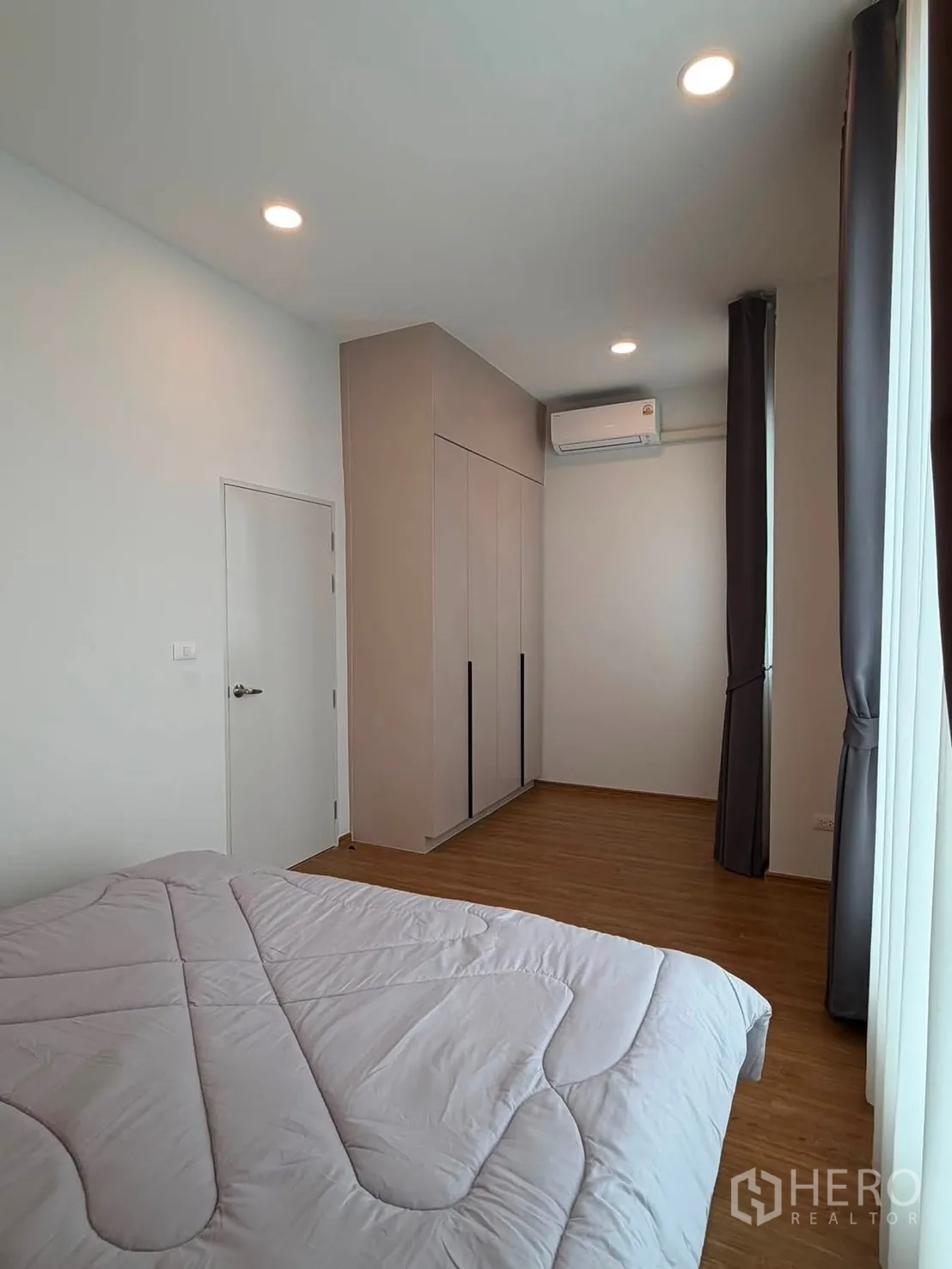 Townhouse for rent in Bang Phli, Samut Prakan - Spacious bedroom with bed, built-in wardrobe, large windows and curtains.
