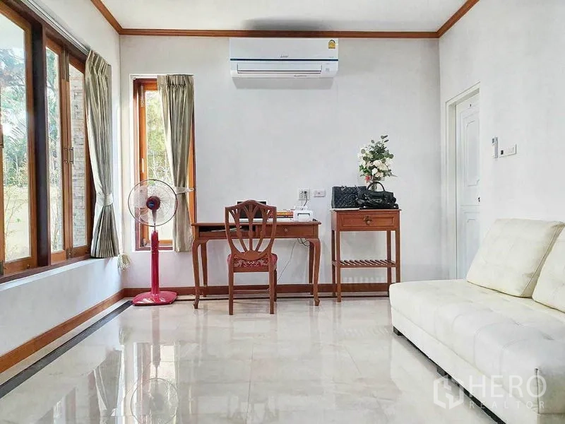 Detached House for sale in Taling Chan, Bangkok - Bright study and living corner with desk, sofa and wide windows.