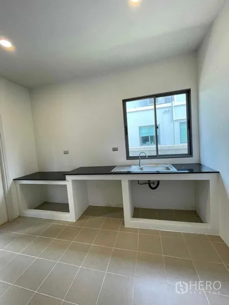 บ้าน ขายในNuea Khlong, Krabi - ห้องครัวแบบเรียบง่าย เคาน์เตอร์ท็อปสีดำยาว อ่างล้าง และหน้าต่าง