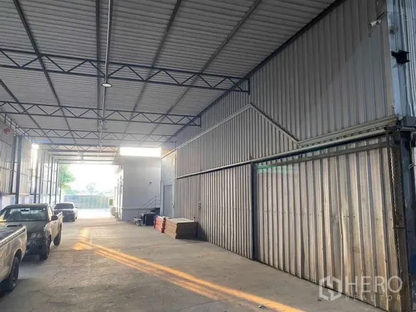 Warehouse for sale in Mueang Samut Prakan, Samut Prakan - Drive-through loading bay with sliding metal doors and easy vehicle access.