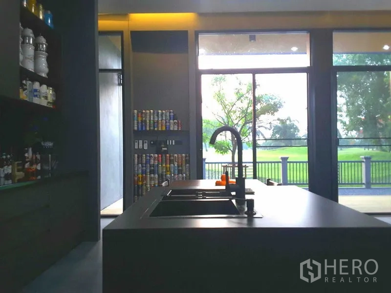 บ้าน ให้เช่าหรือขายในLam Luk Ka, Pathum Thani - ครัวไอส์แลนด์ทันสมัย อ่างล้างจานคู่ หันสู่ประตูกระจกสูงจรดเพดานชมวิวสวนเขียว