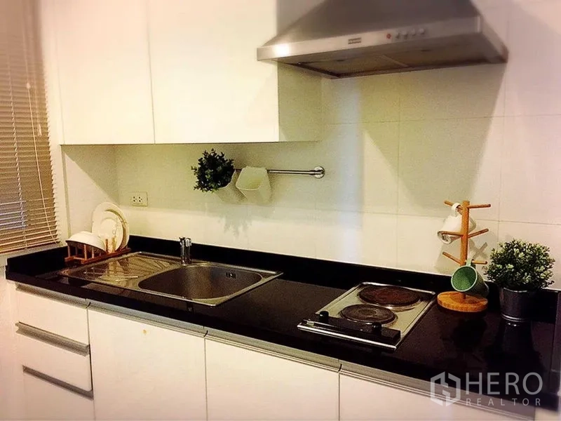 คอนโด ให้เช่าในKhlong Toei, Bangkok - ครัวรูปแบบแกลลีย์ ท็อปหินสีดำ ซิงก์ เตาไฟฟ้า และเครื่องดูดควัน