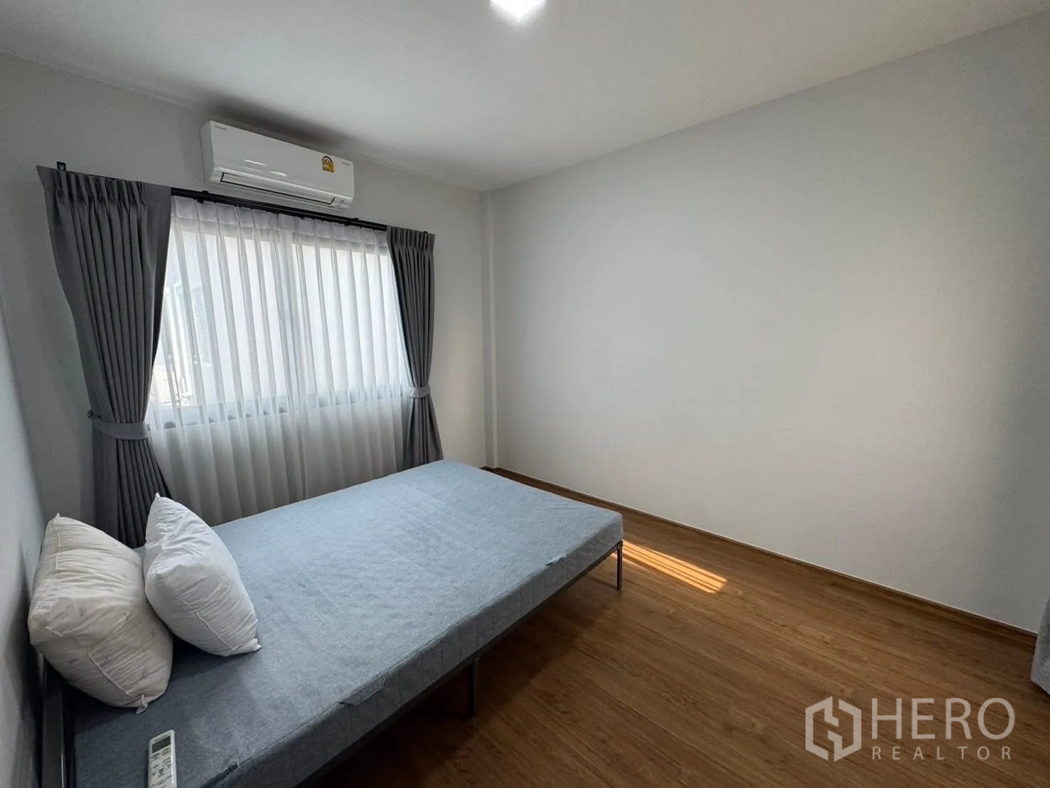 Townhouse for rent in Bang Phli, Samut Prakan - Guest bedroom with single bed, air conditioning, and window with sheer drapes.