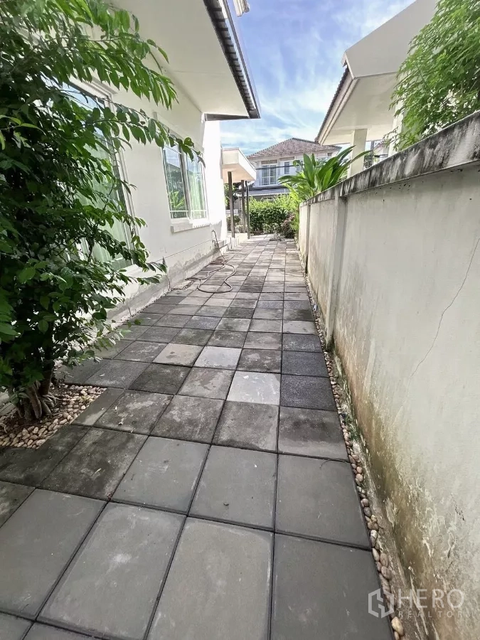 บ้าน ขายในBang Kapi, Bangkok - ทางเดินข้างบ้านปูกระเบื้องบล็อกและกำแพงสวน