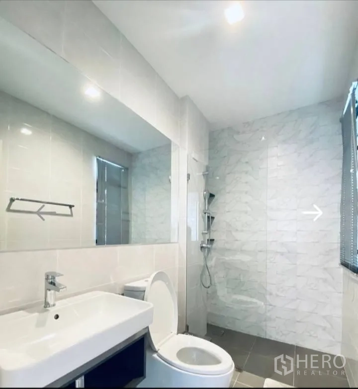 Detached House for sale in Saphan Sung, Bangkok - Bathroom with vanity, toilet and a glass-enclosed shower area.