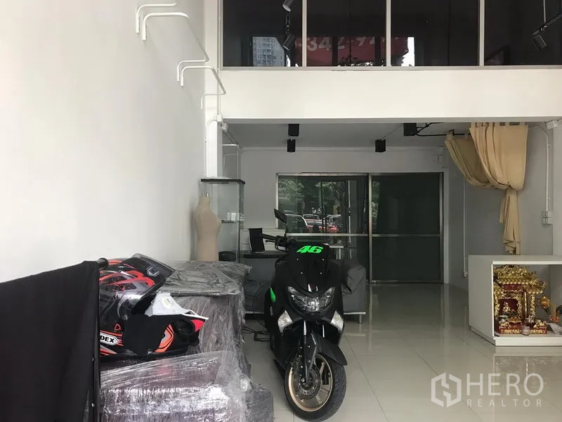 零售空间 出租在Khlong Toei, Bangkok - 开放式商铺空间，白色墙面，带夹层与滑动玻璃隔断，适合展陈。