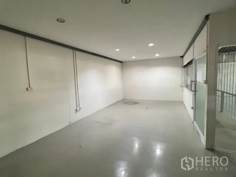Warehouse for rent in Suan Luang, Bangkok - Upper office room with white walls and windows to the warehouse interior.
