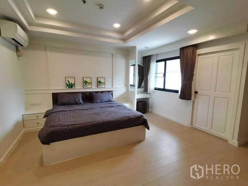 อพาร์ทเมนท์ ให้เช่า - ห้องนอนสว่างด้วยหน้าต่างบานใหญ่ มีโต๊ะทำงานและเตียงคิงไซส์