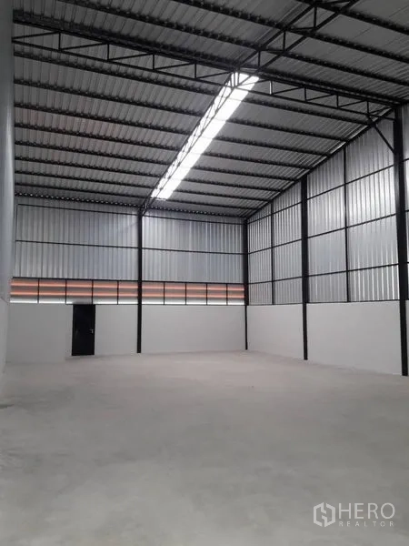 货栈 出租在Lam Luk Ka, Pathum Thani - 仓库内部，约7米挑高钢结构屋顶，中部天窗灯带与混凝土地面。