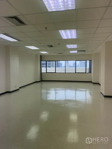 Office Space for rent in Watthana, Bangkok - Bright open-plan office with wide windows, city views, suspended ceiling and fluorescent lighting.