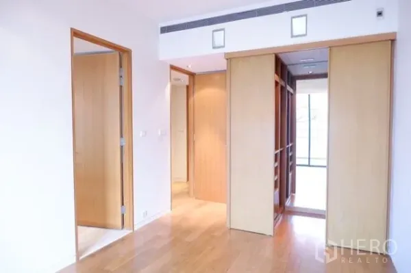 公寓 出售在Sathon, Bangkok - 主卧带步入式衣帽间与温润木质收纳。